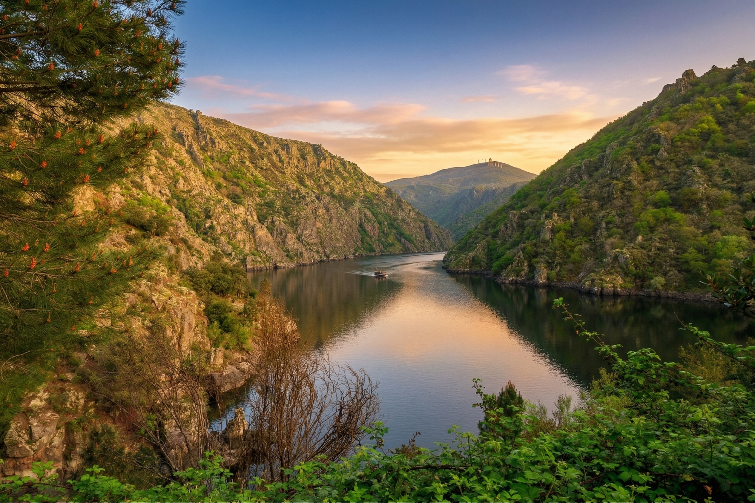 Vista panorámica de los Cañones del Sil en la Ribeira Sacra bajo la luz del atardecer. Un pequeño barco navega por las aguas tranquilas del río, rodeado de altas montañas rocosas y abundante vegetación. Una excursión de naturaleza imprescindible para los huéspedes de los alojamientos turísticos de Urbe Lucus en Lugo.